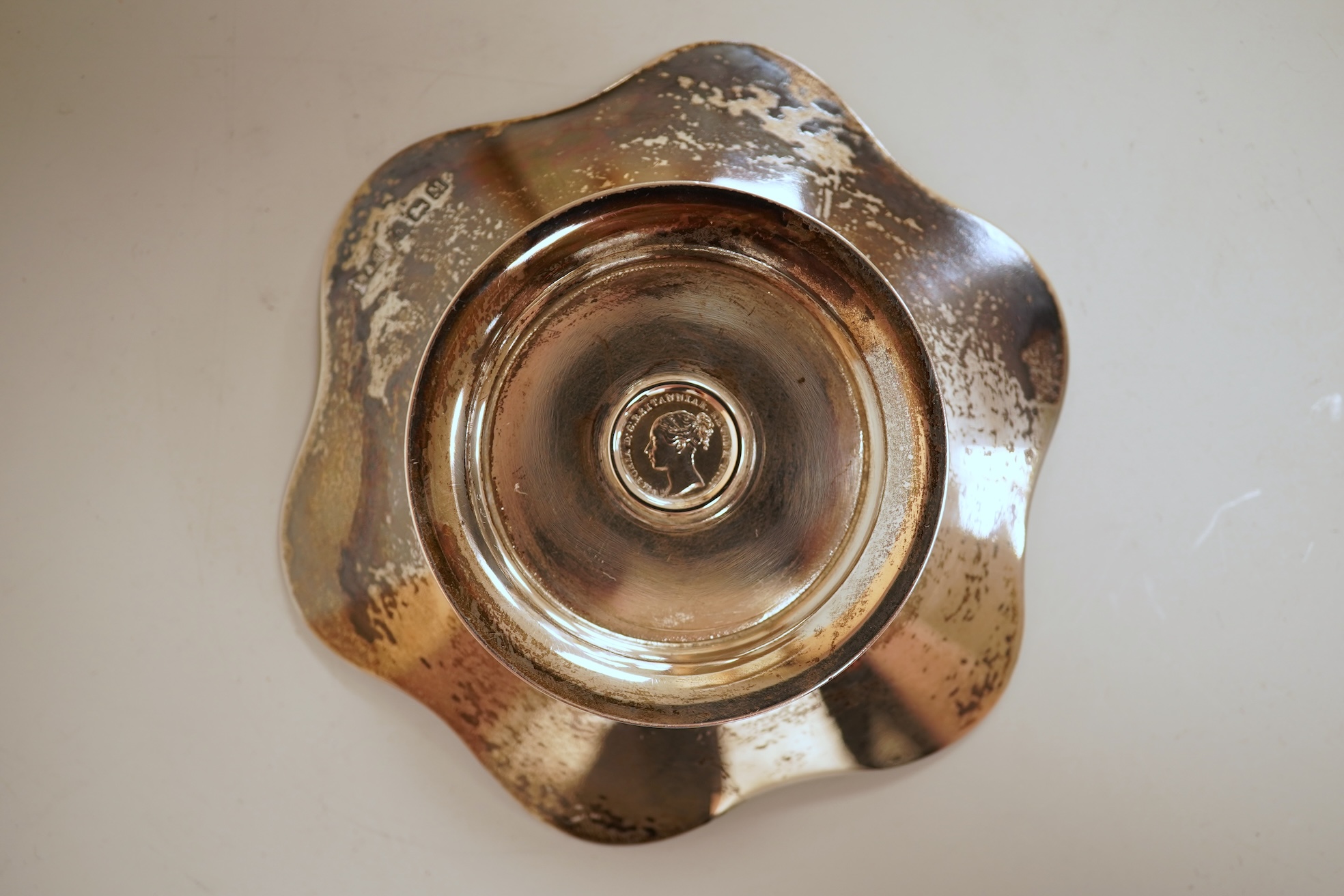 A cased set of four George V silver flower head shaped nut dishes, each inset with an 1850 maundy coin, Walker & Hall, Birmingham, 1936, diameter 77mm.